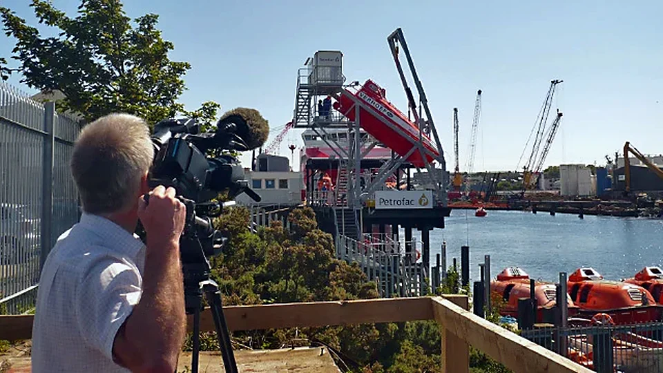 A Cinécosse cameraman filming at a harbour construction site